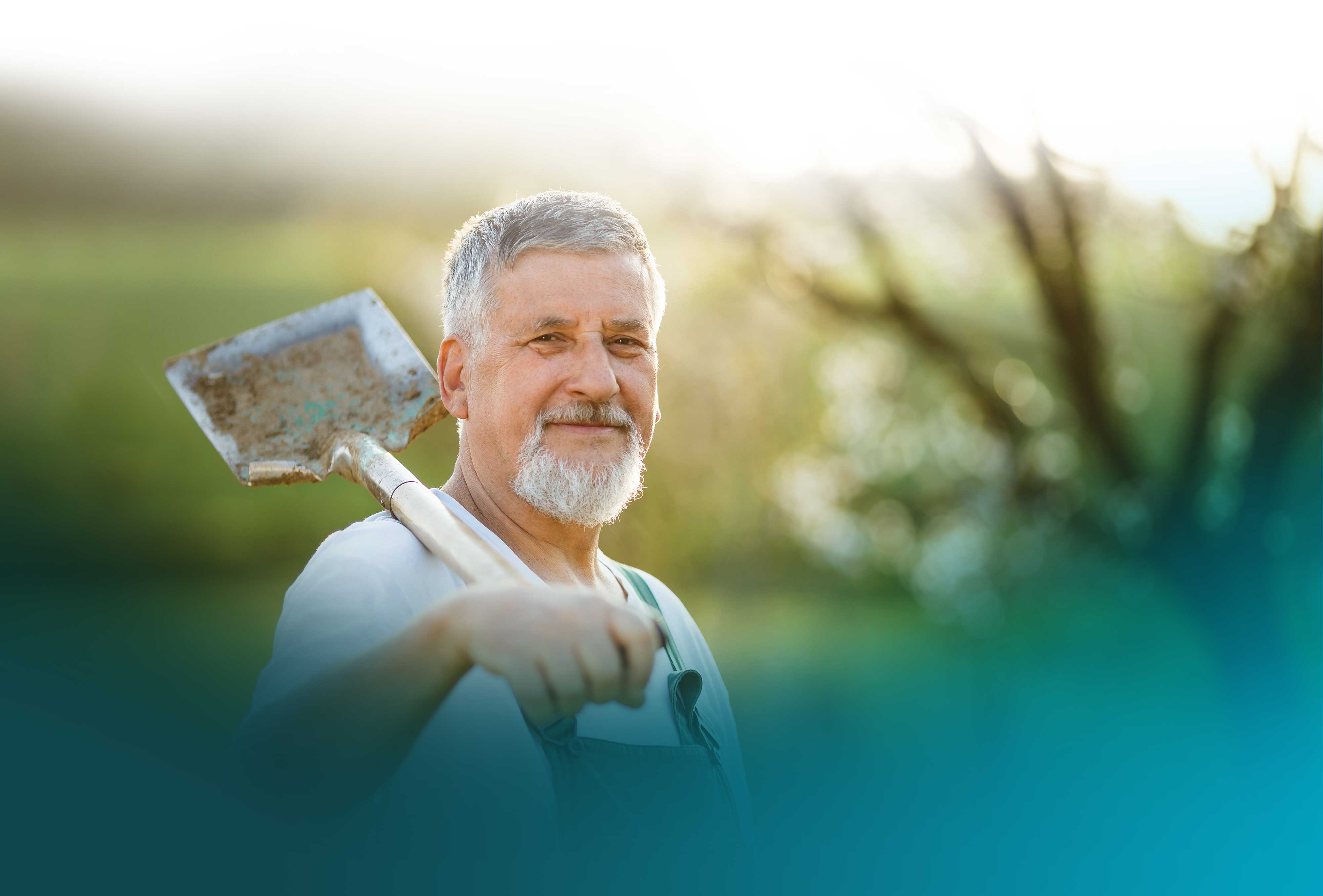 Elderly man with a shovel on his shoulder