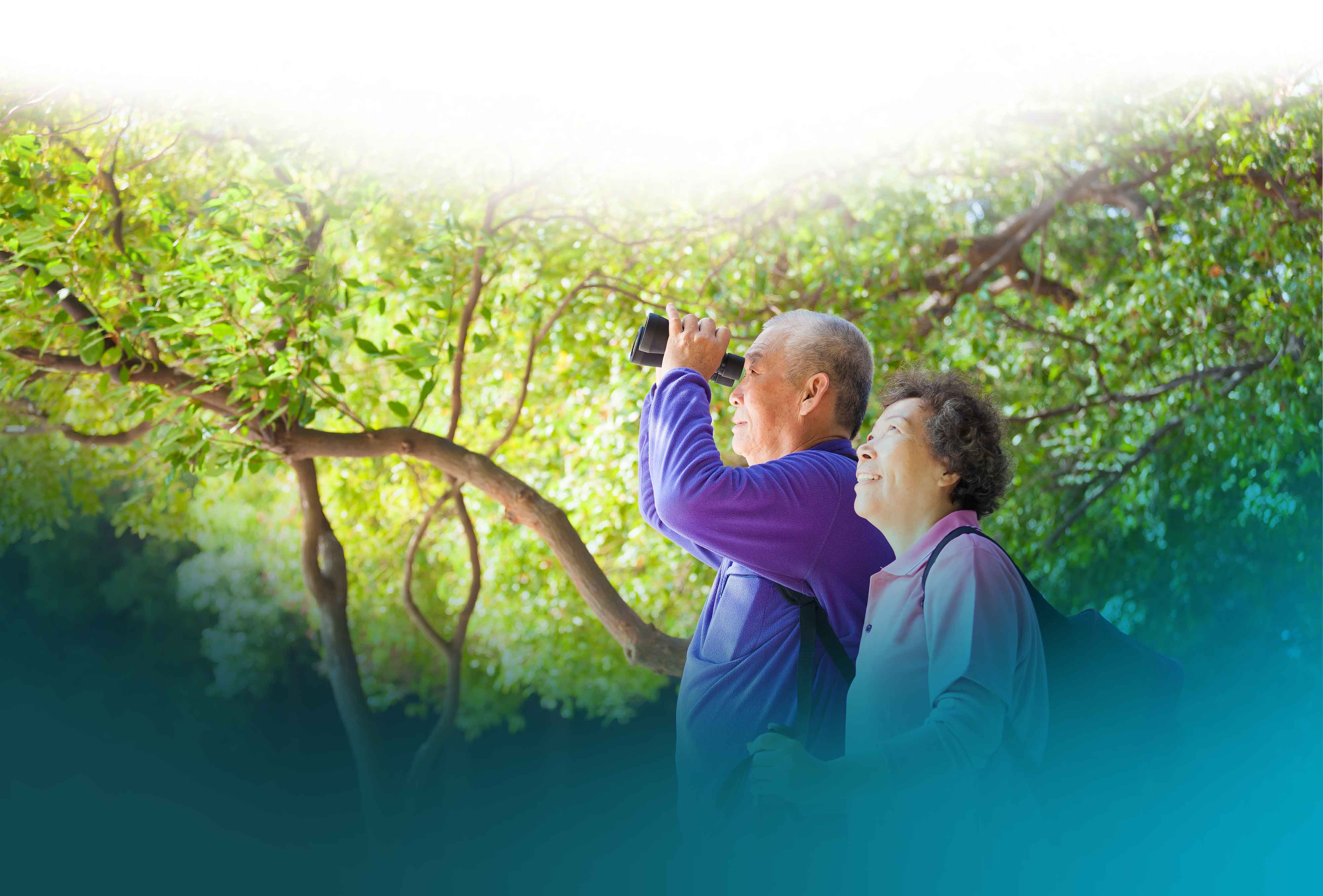 Elderly couple with binoculars in nature